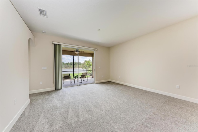 carpeted spare room with baseboards and arched walkways