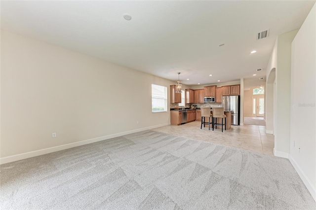 living room with baseboards, light carpet, recessed lighting, and arched walkways