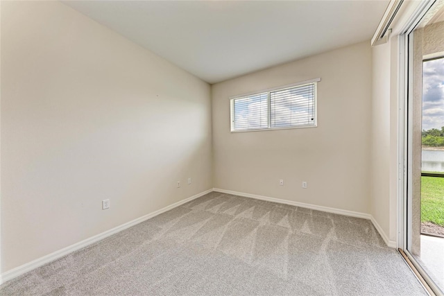 empty room featuring light colored carpet and baseboards