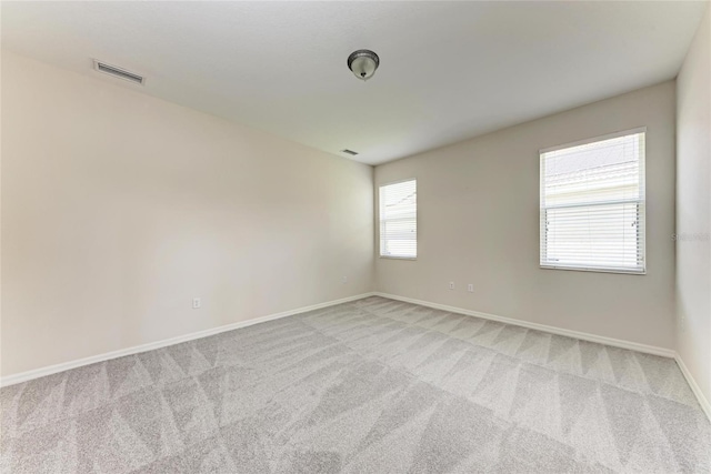 empty room with light colored carpet and baseboards