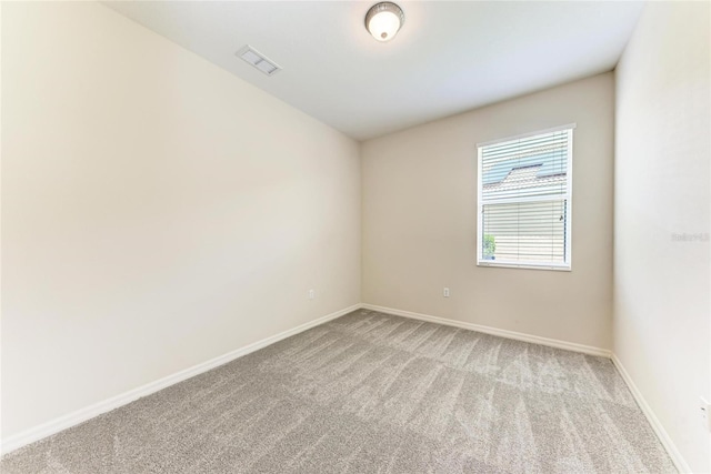 empty room featuring light colored carpet and baseboards