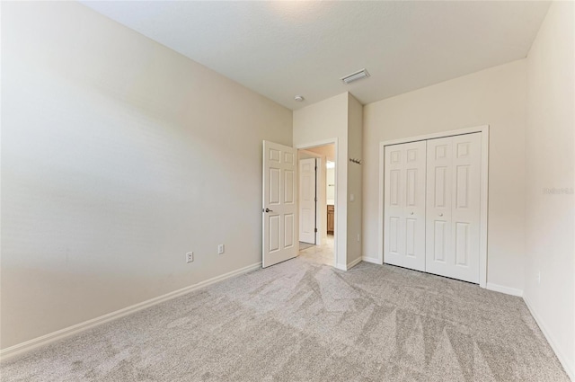 unfurnished bedroom with light colored carpet, baseboards, and a closet