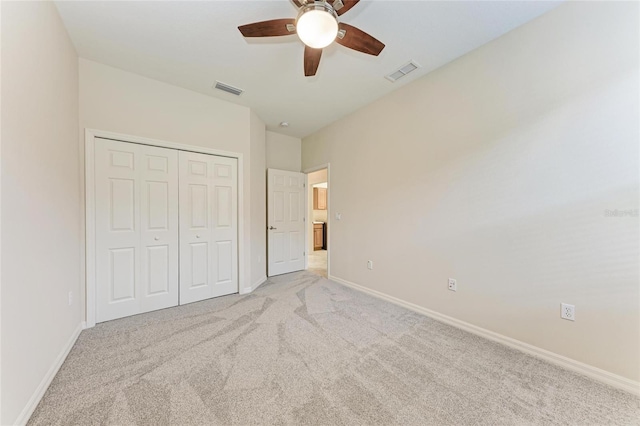 unfurnished bedroom with light carpet, baseboards, and a closet