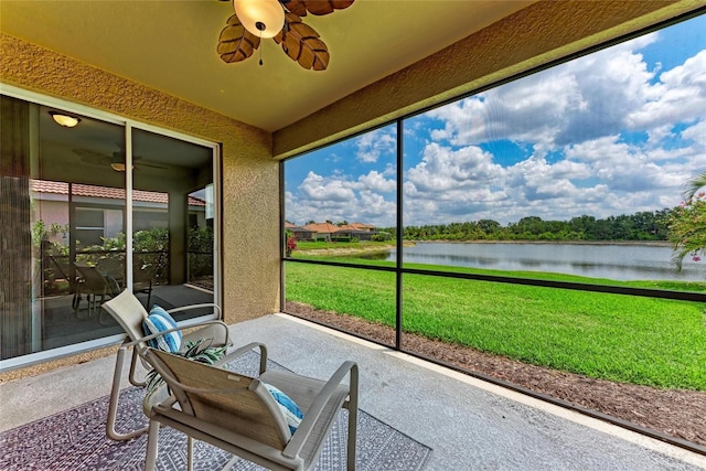 sunroom with a water view and ceiling fan