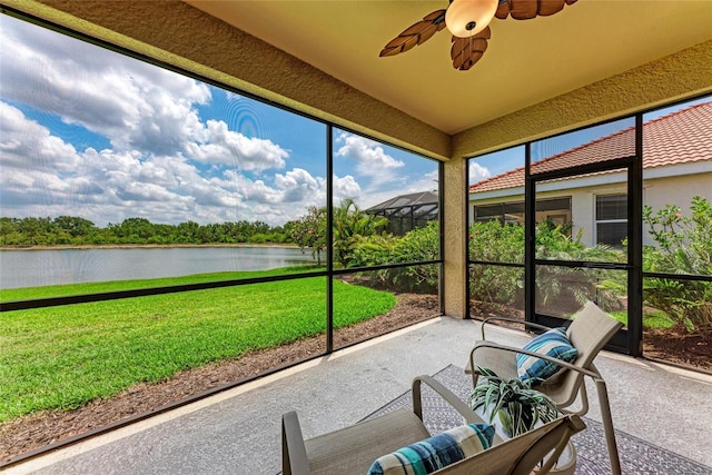sunroom with a water view and ceiling fan