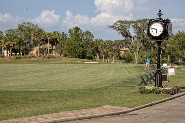 view of community featuring a yard, golf course view, and view of scattered trees