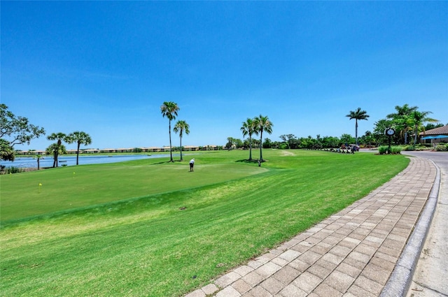 surrounding community featuring view of golf course, a lawn, and a water view