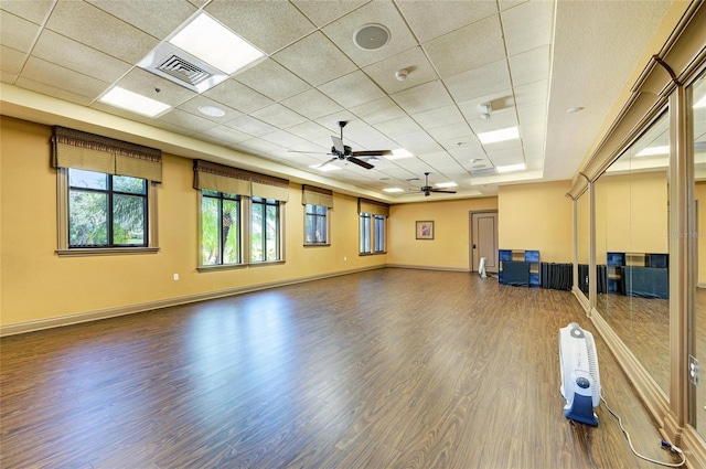 workout room featuring a ceiling fan, wood finished floors, a drop ceiling, and baseboards