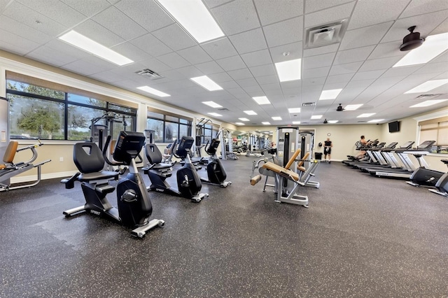 gym with a drop ceiling and baseboards