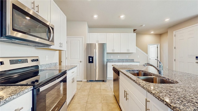 1824 Woodleaf Hammock Ct, Bradenton, FL 34211 - kitchen with stainless steel appliances, a sink, white cabinetry, light stone countertops, and light tile patterned floors