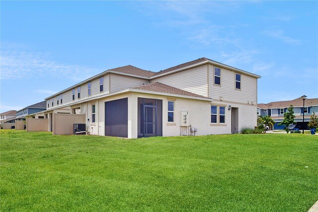 1824 Woodleaf Hammock Ct, Bradenton, FL 34211 - rear view of property featuring roof with shingles, a lawn, central air condition unit, a sunroom, and stucco siding