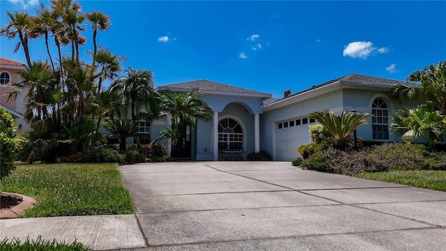 view of front of home featuring an attached garage, concrete driveway, and stucco siding