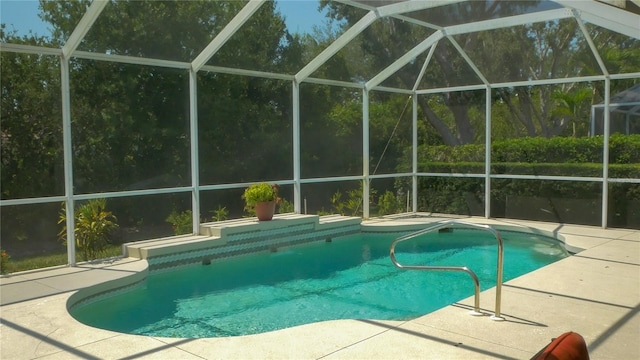 outdoor pool with a patio area and glass enclosure