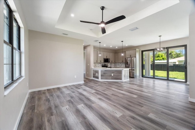 18274 Grace Ave, Port Charlotte, FL 33948 - unfurnished living room featuring light wood finished floors, recessed lighting, ceiling fan, and a tray ceiling