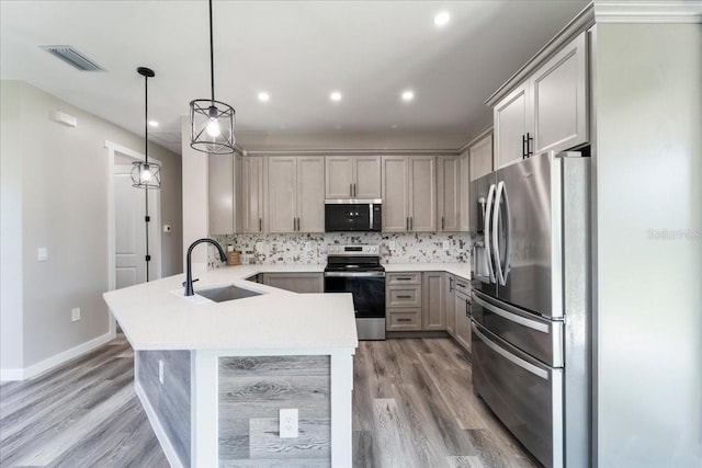 18274 Grace Ave, Port Charlotte, FL 33948 - kitchen with appliances with stainless steel finishes, a peninsula, gray cabinetry, light wood finished floors, and recessed lighting