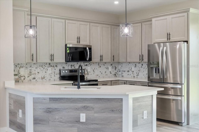18274 Grace Ave, Port Charlotte, FL 33948 - kitchen with stainless steel appliances, a peninsula, light countertops, and backsplash