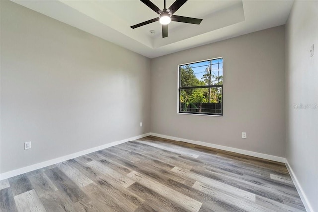 18274 Grace Ave, Port Charlotte, FL 33948 - unfurnished room with a tray ceiling, wood finished floors, and a ceiling fan