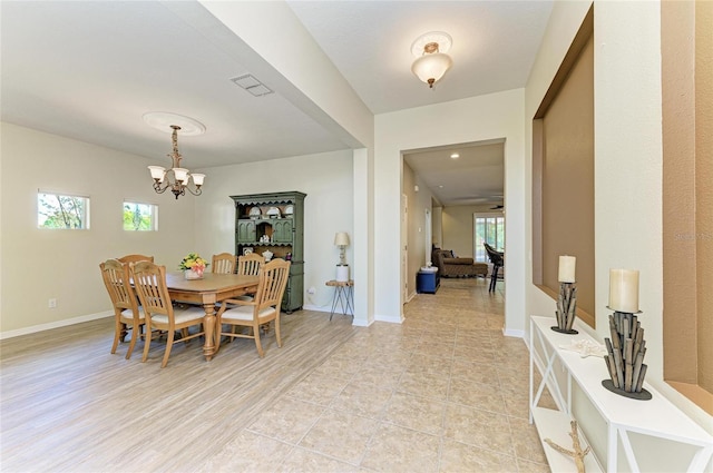 dining room with a chandelier, plenty of natural light, and baseboards