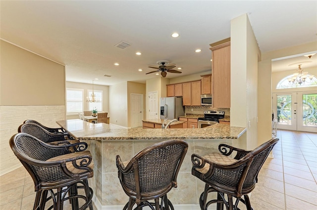 kitchen featuring stainless steel appliances, a chandelier, recessed lighting, a peninsula, and a breakfast bar area