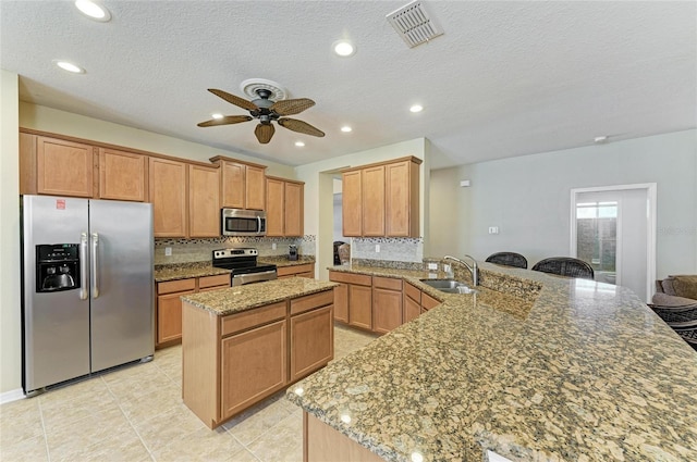 kitchen with stainless steel appliances, a sink, a ceiling fan, light stone counters, and tasteful backsplash