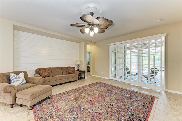 living room featuring ceiling fan, light tile patterned floors, and baseboards