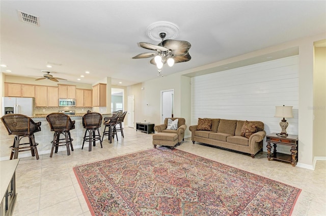 living room featuring a ceiling fan, light tile patterned floors, recessed lighting, and baseboards