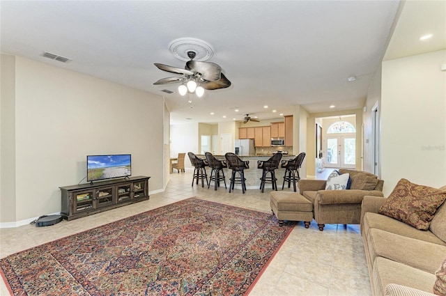 living area with light tile patterned floors, ceiling fan, recessed lighting, and baseboards