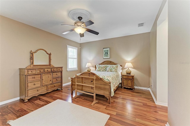 bedroom with light wood-style flooring, baseboards, and a ceiling fan