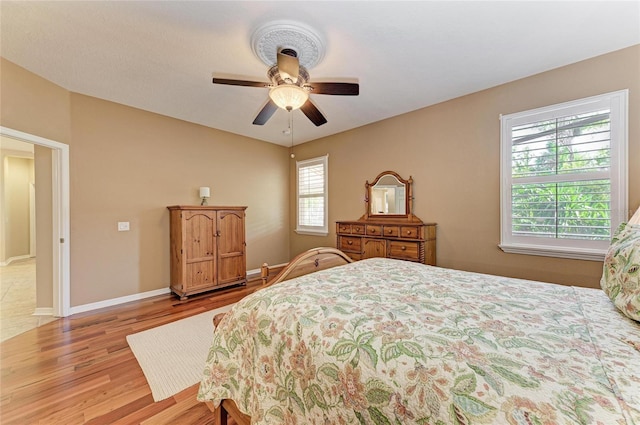 bedroom with wood finished floors, baseboards, and ceiling fan
