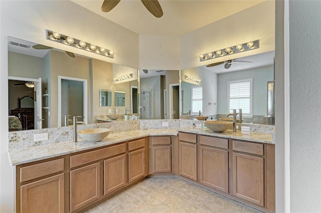 ensuite bathroom with a ceiling fan, tile patterned floors, double vanity, and a shower stall