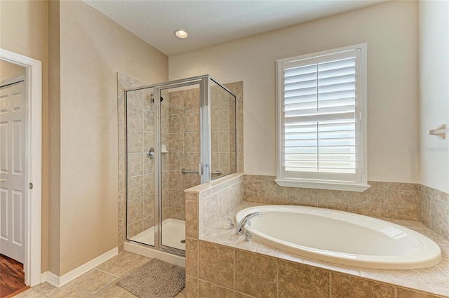 full bath featuring a stall shower, a bath, and tile patterned flooring