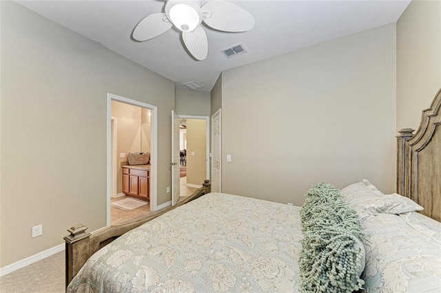 bedroom featuring light carpet, baseboards, a ceiling fan, and ensuite bathroom