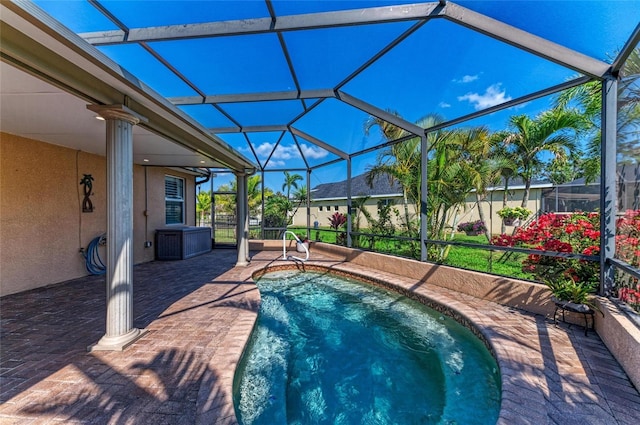 outdoor pool featuring glass enclosure and a patio area