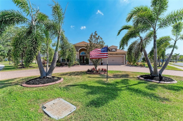 mediterranean / spanish home with curved driveway, a front yard, and a garage