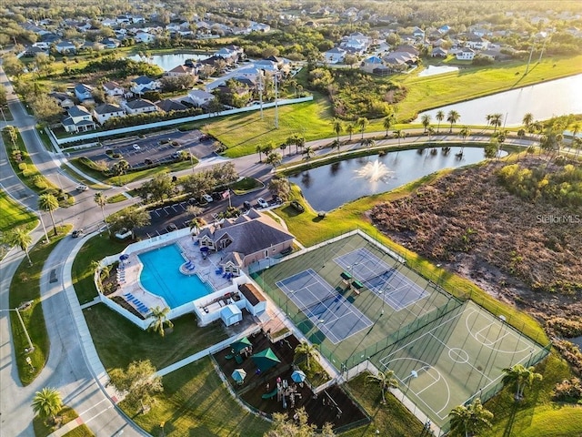 drone / aerial view of a nearby body of water and a pool