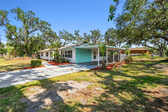 view of front of house with a front yard, a carport, and driveway