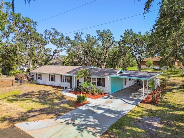 ranch-style home featuring concrete driveway and a carport