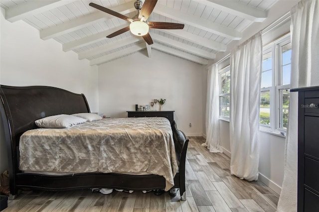 bedroom with wood finished floors, baseboards, ceiling fan, and vaulted ceiling with beams