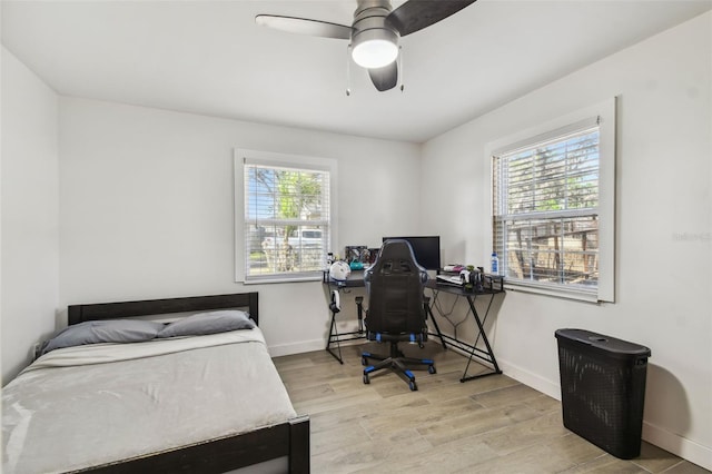 bedroom featuring a ceiling fan, wood finished floors, and baseboards
