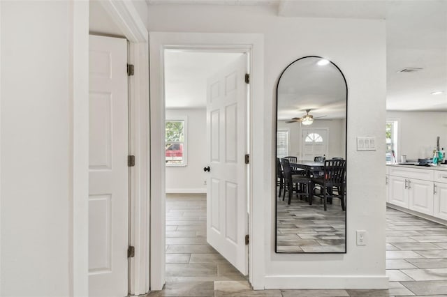 hall with baseboards and wood finish floors