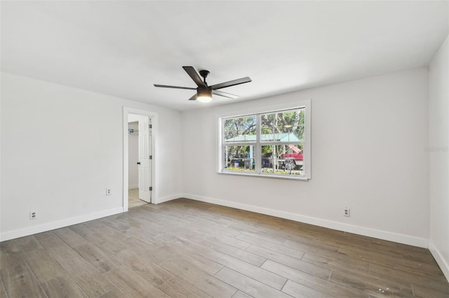 unfurnished room with ceiling fan, baseboards, and wood finished floors