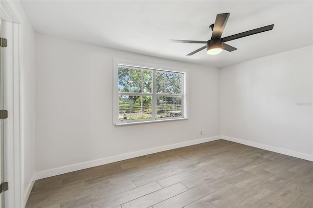 unfurnished room featuring ceiling fan, baseboards, and wood finished floors