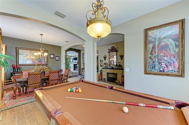 4211 30th Ln E, Bradenton, FL 34208 - game room with pool table, light wood finished floors, visible vents, a chandelier, and a fireplace