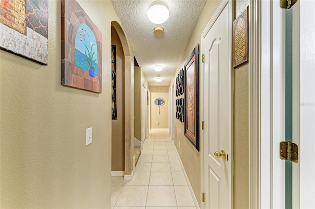4211 30th Ln E, Bradenton, FL 34208 - hall with light tile patterned floors, a textured ceiling, and a textured wall