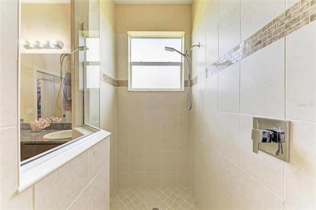 bathroom with tiled shower and vanity