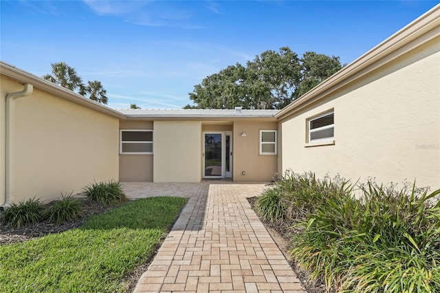 doorway to property featuring stucco siding