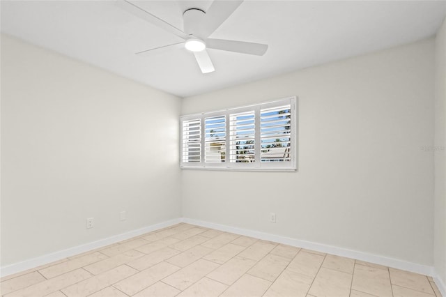 empty room with a ceiling fan and baseboards