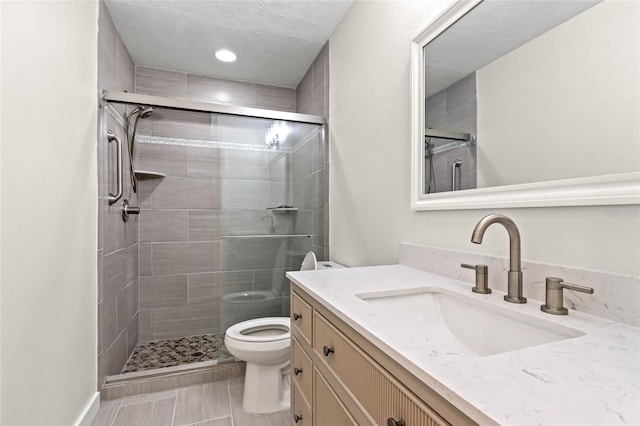 full bathroom featuring a stall shower, vanity, toilet, and recessed lighting