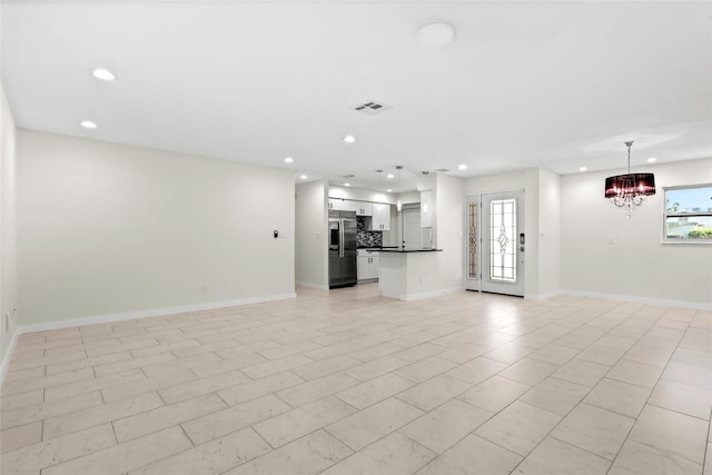 unfurnished living room featuring an inviting chandelier, plenty of natural light, visible vents, and recessed lighting