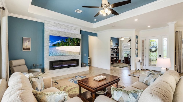 20359 Cristoforo Pl, Venice, FL 34293 - living area featuring ceiling fan, ornamental molding, a stone fireplace, a tray ceiling, and recessed lighting